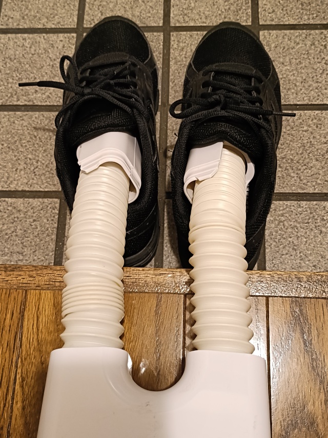 スニーカーに靴乾燥機のホースを差し込んだ状態